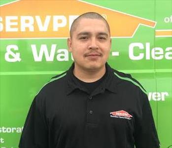 Man wearing black shirt in front of green background