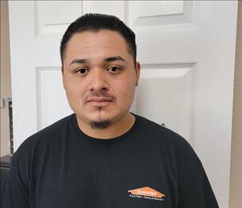 man black shirt, white door behind him