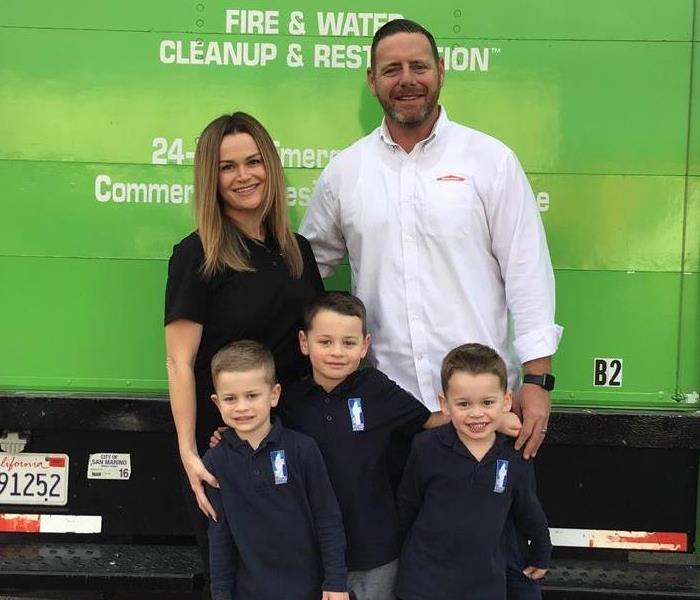 Family standing in front of green truck