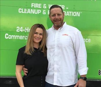 Woman and man in front of green truck